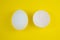 White egg and eggshell on the yellow background. Copy space. Minimalism, original and creative photo. Beautiful wallpaper. Easter