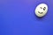 White egg with painted smiling face on blue background