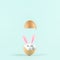 White egg with rabbit ears in cracked eggshell against pastel blue background. Easter minimal concept. Creative Happy Easter or