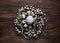 White egg surrounded with quial eggs in nest of gypsophila flowers