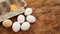 White eggs carton and cracked egg half with yolk top view on wooden background