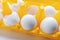 White eggs in yellow packaging close up