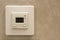 White electronic programmable digital thermostat on light wall copy space background. Climate control, comfortable home