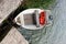 White empty boat with oars on the water near concrete beach