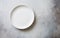 White empty ceramic plate on  gray stone background