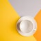 White empty coffee Cup on bright yellow-orange-beige-gray background. concept of autumn cafe menu