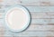 White empty dinner plate with blue border on wooden table