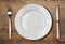 White empty dinner plate setting on wooden table