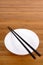 White empty rice bowl with wooden chopsticks on a bamboo background