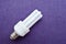 White energy-saving fluorescent light bulb with four tubes, with a silver cap