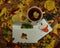 A white envelope with a beautiful mulberry leaf and a card with hearts lie next to a cup of fresh tea