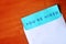 White envelope and blue paper on wooden table