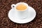 White espresso cup sat on coffee beans