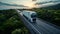 white European semitruck is seen from the sky on a highway backed by vegetation