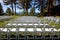 White event chairs in scenic garden by a lake