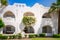 The white facade of an expensive and luxurious hotel. Many flowers on the balcony of the villa in the resort town