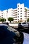 White facades of houses are reflected on car windows