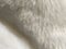 White faux fur. Close-up. Partially defocused photo. Fluffy villi