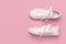 White female fashion sneakers on pink background. Flat lay, top view, copy space. Women`s shoes. Stylish white sneakers. Fashion