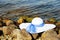 White female hat with broad brim and blue ribbon on stones Bank rivers