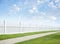 White fence, grass, sidewalk, blue sky and clouds