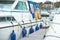 White fenders suspended between a boat and dockside for protection. Maritime fenders