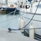 White fenders suspended between a boat and dockside for protection. Maritime fenders