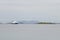 White ferry passing a small islet with small lighthouse on it in Vega archipelago