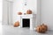 White fireplace with carved pumpkins, side view