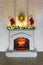 White fireplace with fire decorated for Christmas with candles, Santa Claus socks with gifts, new year fir tree branch and wreath