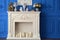 White fireplace with a mirror in the room, on the shelf watches, Souvenirs, candles