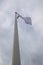 White flag on the mast near the beach. Flag on a background of cloudy sky