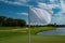 White flag with a place to write. Countryside golf course with flag, greens and water. Golf course in the countryside.