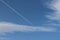 A white, flat plane track in the blue sky.