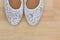 White floral lace ballet flat slip on shoes on wooden background