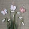 White flowers of snowdrops galanthus and crocheted pink and white butterflies on gray linen homemade fabric.