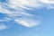 White fluffy cirrus clouds in a stratosphere. Light fiber like spindrift clouds high in the blue summer sky. Different cloud types