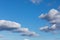 White, fluffy cloud float along the skyline over blue sky on a clear day. Background from clouds