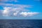 White fluffy cloud over still blue sea. Nautical minimal landscape. Blue sea and sky landscape. Summer travel card