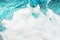 White foam blue water background closeup, sea or ocean foam wave pattern, froth bubbles texture, soap spume backdrop, soap sud