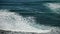 White foamy breaking waves on the beach with black volcanic sand on Tenerife.