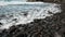 White foamy breaking waves on the beach with black volcanic sand on Tenerife.