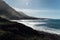 White foamy breaking waves on the beach with black volcanic sand on Tenerife.