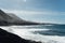 White foamy breaking waves on the beach with black volcanic sand on Tenerife.