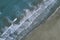 White foamy sea waves splash to deserted sandy beach in the evening. Evening surf. Aerial top view from UAV drone