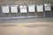 White folded chairs in the row on concrete background.  Stacking chairs in Public space.