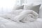 White folded duvet lying on white bed background. Preparing for winter season, household, domestic activities, hotel or