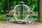 White forged decorative coach with flowers in park