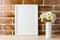 White frame mockup with daisy bouquet near exposed brick wall