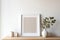 White frame mockup on table. Small white vase with dry leaves and grass.